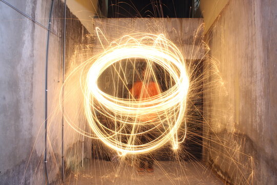 time-lapse of round sparkling light and a man indoor