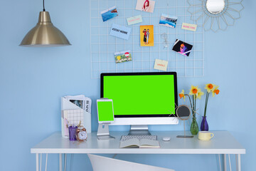Modern devices with blank screen at workplace in room