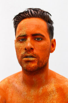 Topless man with orange painting on his face