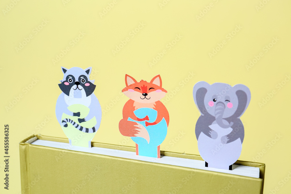 Wall mural Cute bookmarks with book on color background