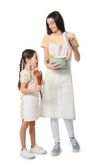 Young mother and daughter with kitchen utensils on white background