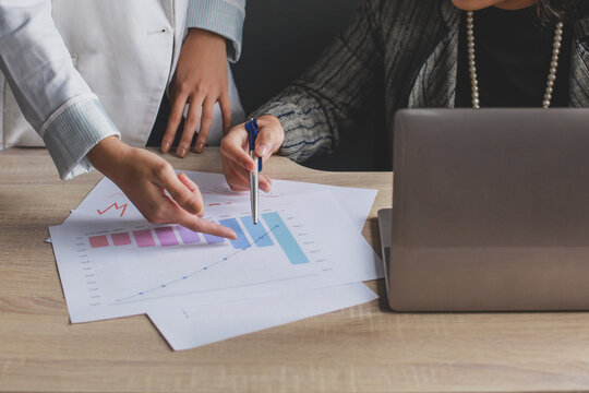 Two Women Discussing Bar Chart