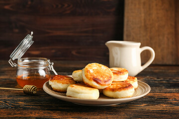 Plate with tasty cottage cheese pancakes on table