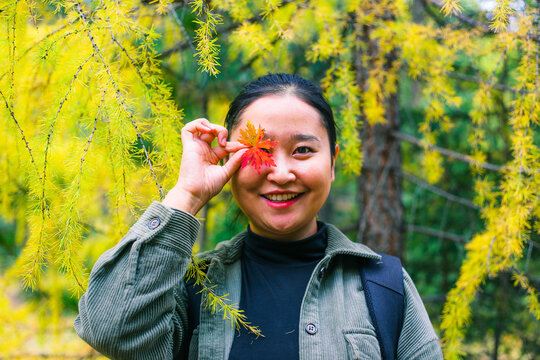Woman holding orange leaf to her eyes