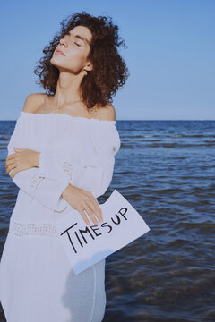 Woman holding paper saying " Time's Up"
