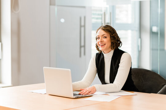 Woman in black cardigan sitting by the table using MacBook