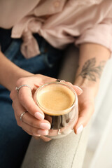 Woman drinking tasty coffee at home, closeup