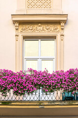 Fototapeta na wymiar Antique window and balcony decorated with flowers
