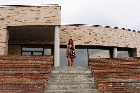 Woman in floral dress standing on staircase outdoor