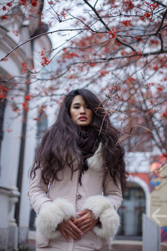 Woman in light coat standing outdoor