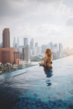 woman in swimming pool on rooftop of skyscraper