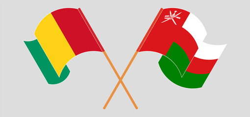 Crossed and waving flags of Guinea and Oman