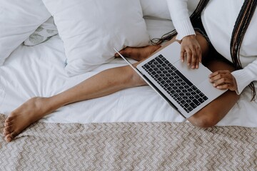 Woman using laptop on bed