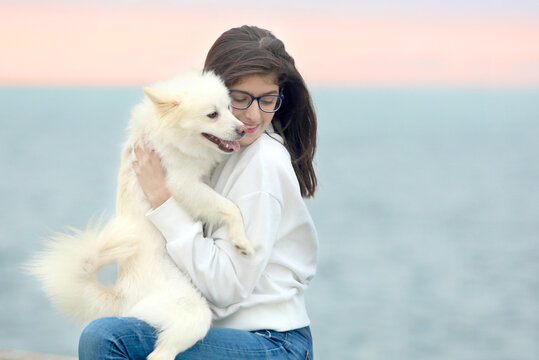 Woman wearing eyeglasses holding a puppy outdoor