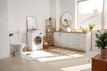 Interior of bathroom with modern washing machine