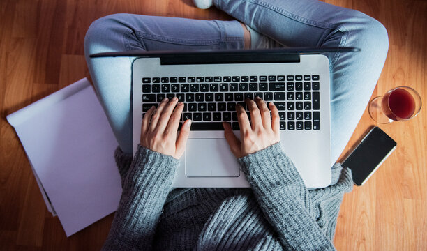 Woman working on laptop while sitting on the floor