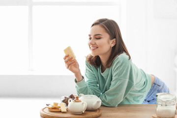 Beautiful young woman with tasty chocolate at home