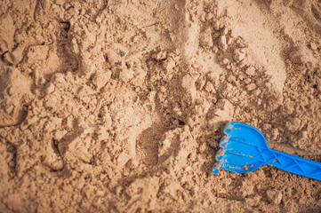 Children's blue toy on the sand and copy space...