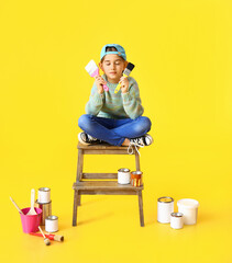 Little painter with brushes on color background