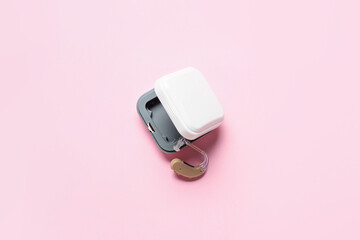 Box with hearing aid on color background