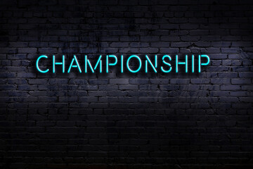 Night view of neon sign on brick wall with inscription championship