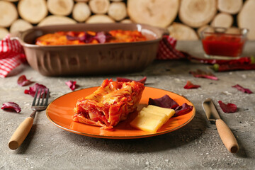 Obraz na płótnie Canvas Plate with piece of tasty tomato lasagna on table