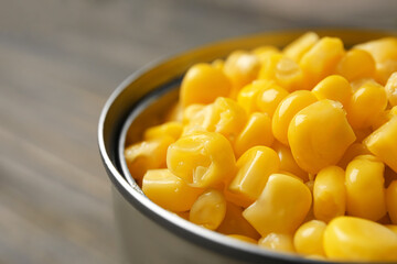 Tin can with corn kernels on table, closeup