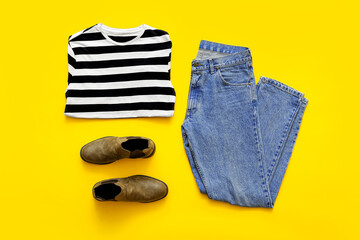 Stylish clothes and shoes on color background