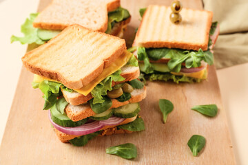 Board with tasty sandwiches on color background, closeup