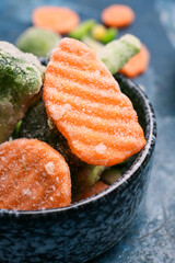 Bowl with frozen vegetables on color background, closeup