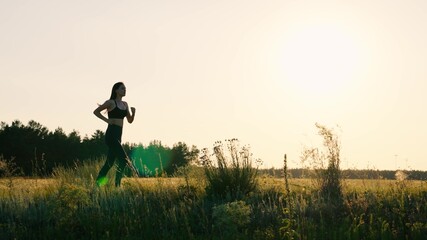 Run and lose weight. Young woman in summer runs through park at sunset. Run after sun. Healthy jogging and outdoor exercise concept. Jogging workout in sun. Goes in for sports at dawn. Autumn training