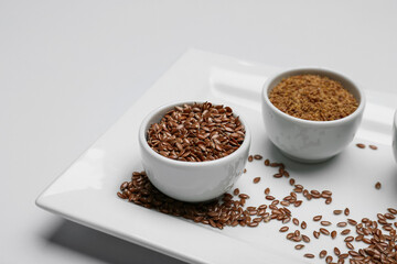 Bowls with flax seeds on light background, closeup