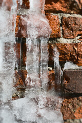 Old red bricks with thick winter ice on them.