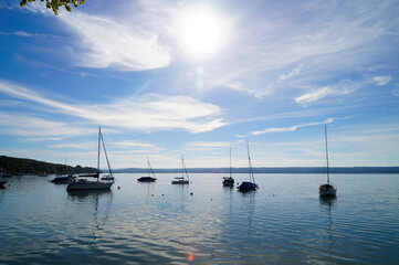 a scenic view of sailing boats in the sun at the bay on lake Ammersee in Germany	