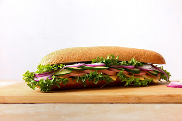 Board with tasty sandwich on light background