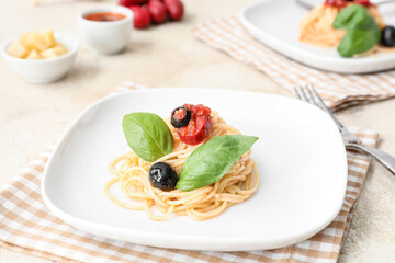 Plate with tasty Pasta Puttanesca on light background
