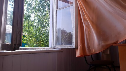 Fototapeta na wymiar orange curtain on the open window with copy space