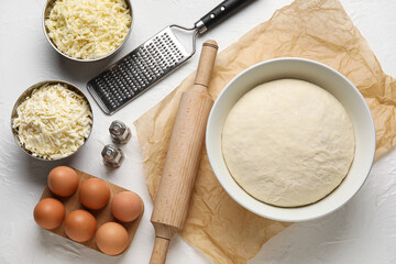 Fresh dough and ingredients for khachapuri on light background