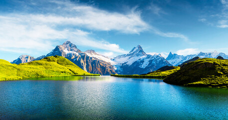 Panorama of Bachalpsee lake in Swiss Alps mountains. Snowy peaks of Wetterhorn, Mittelhorn and Rosenhorn on background. Grindelwald valley, Switzerland. Landscape photography