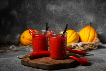 Glasses of tasty bloody Mary cocktail decorated for Halloween on dark background