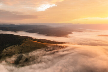 Fototapeta na wymiar Amazing flowing morning fog in summer mountains. Beautiful sunrise on background. Landscape photography