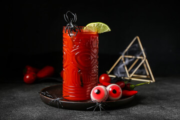 Glass of tasty bloody Mary cocktail decorated for Halloween on dark background