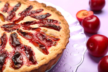 Plate with tasty plum pie on color background, closeup