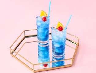Glasses of Blue Lagoon cocktail on color background