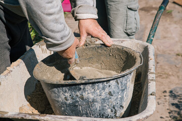 Kneading cement for pouring garden path, garden construction work
