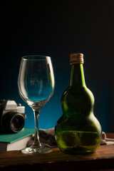 wine glasses and bottles and 35mm analog camera with on table with colored background