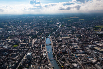 Aerial view of skyline of Dublin with river flowing with bridge connecting two sides of street surrounded by buildings during a cloudy day