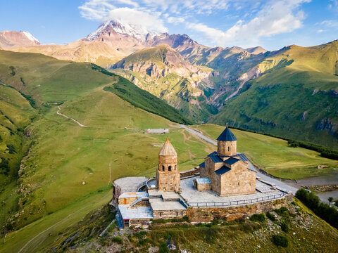 Aerial close up view of Kazbek mountain and Gergeti Trinity Church in Georgia at sunrise