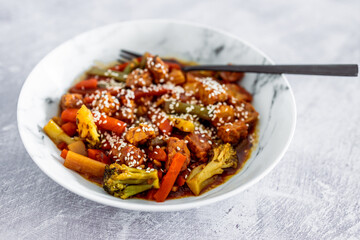 vegan asian stir fry with marinated tofu cubes in kecap sauce, healthy plant-based food
