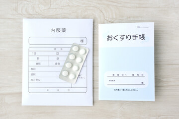 模造品のおくすり手帳と内服薬の袋